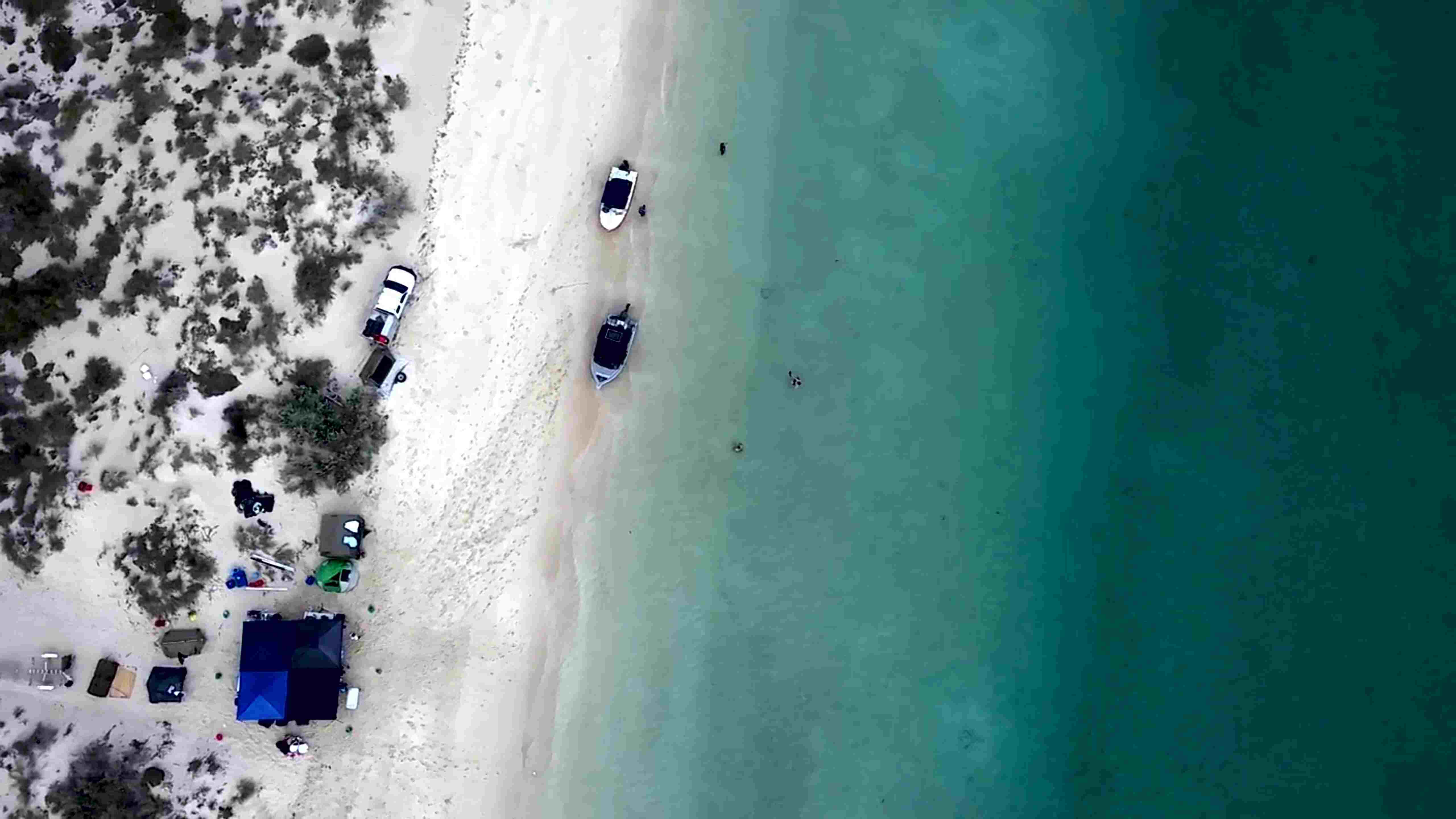 Ningaloo station form the air, camping adventure, people camping on beach, boats on the shore, stingrays in the water