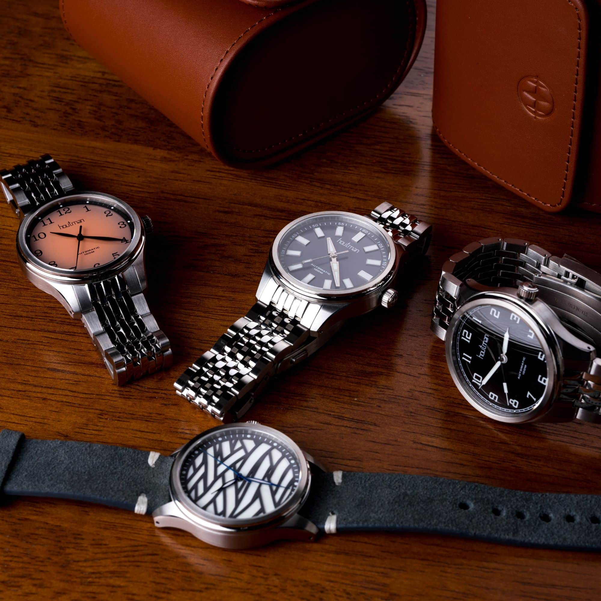 Field watch, sport watch, aviator watch, and special lume watch sitting on wooden desk